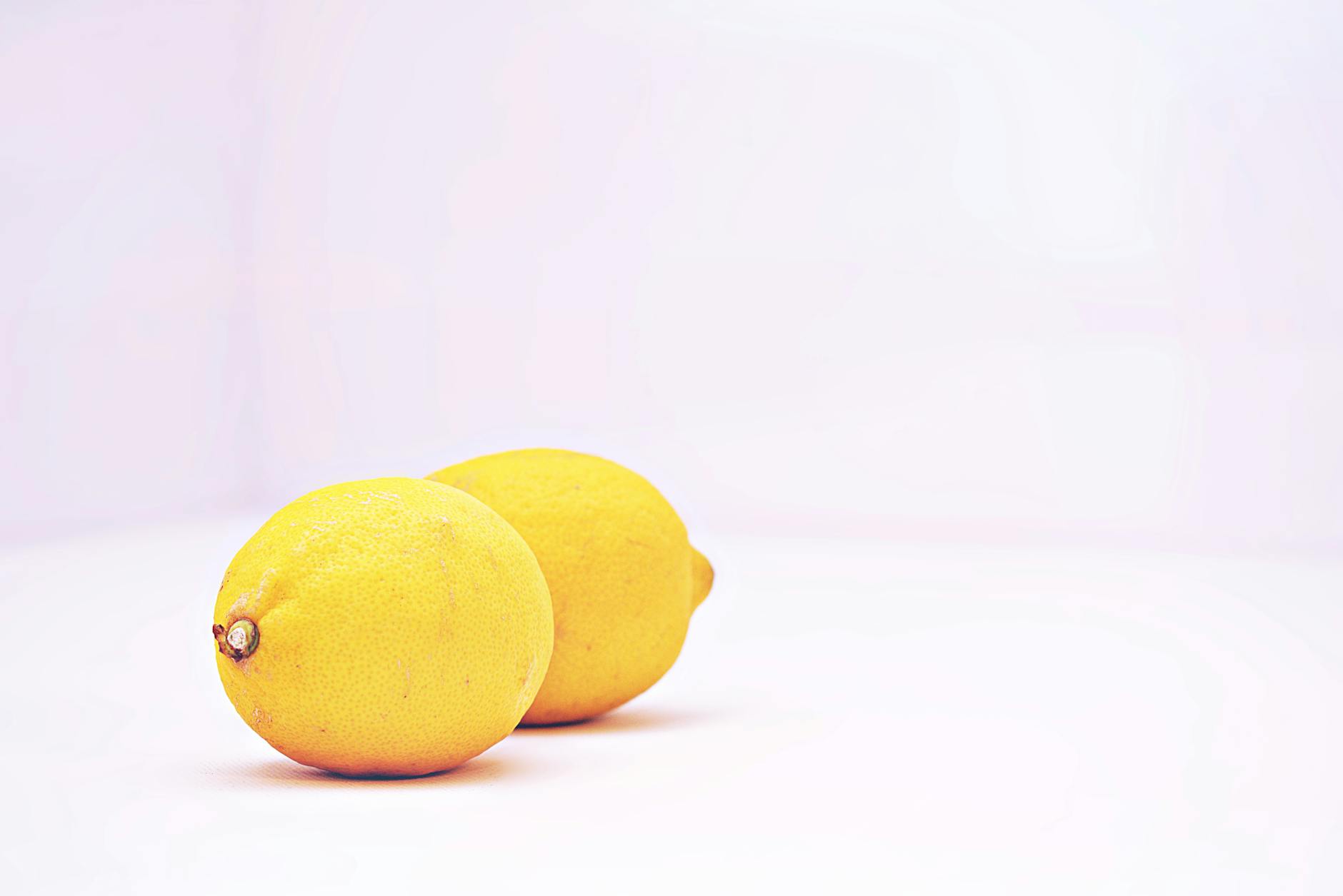 Limoni vibranti su sfondo bianco minimale, simbolo di freschezza e nuovi inizi