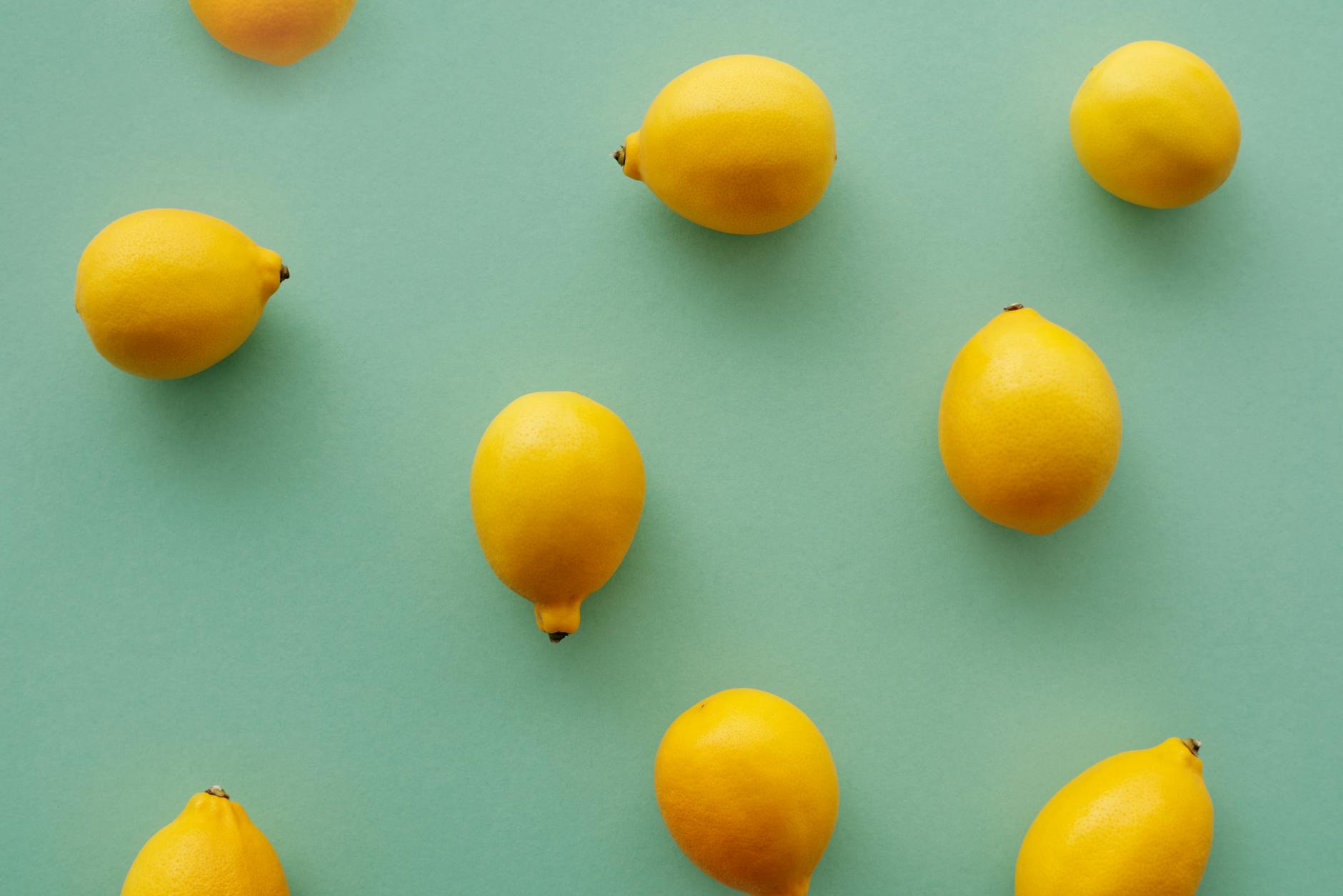 Limoni affettati su uno specchio che proiettano ombre, con composizione minimalista e stile artistico
