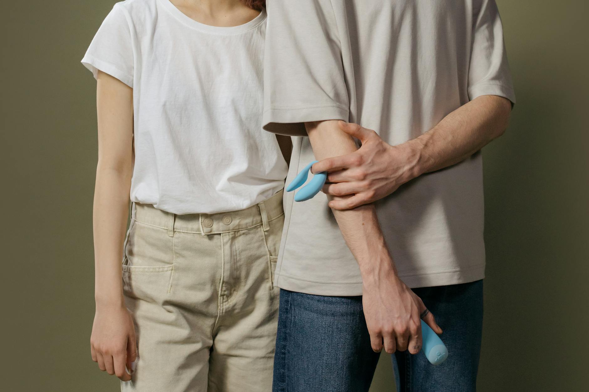 Una giovane coppia insieme che esplora l'intimità moderna con un vibratore blu
